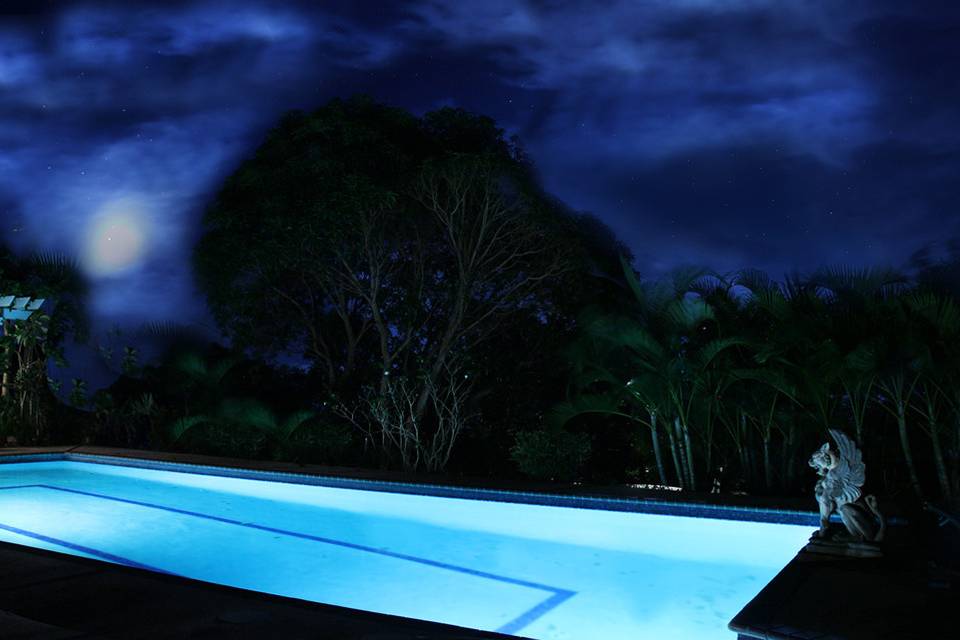Moon shines down on the pool at night.