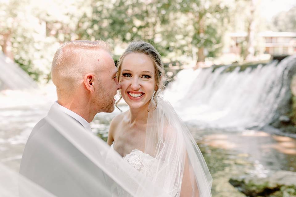 Veil swoops by smiling bride