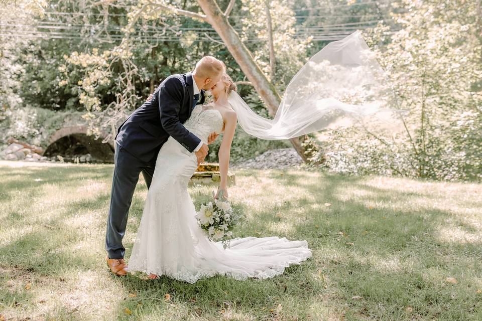 Groom dips bride flying veil