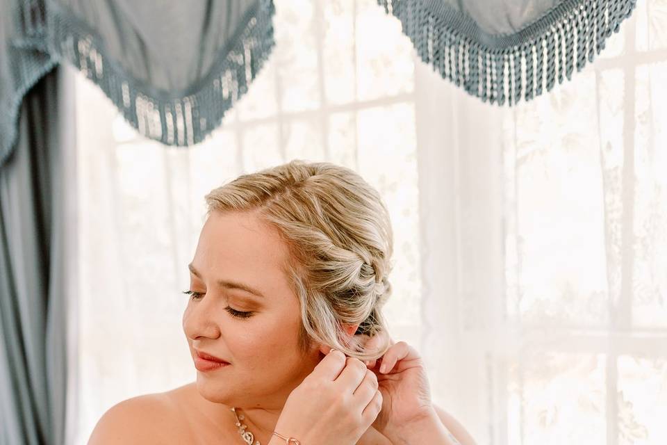 Bride applies earring