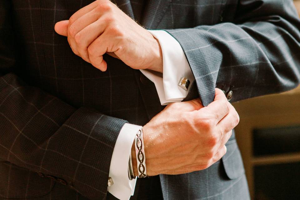 Groom adjusting shirt cuffs