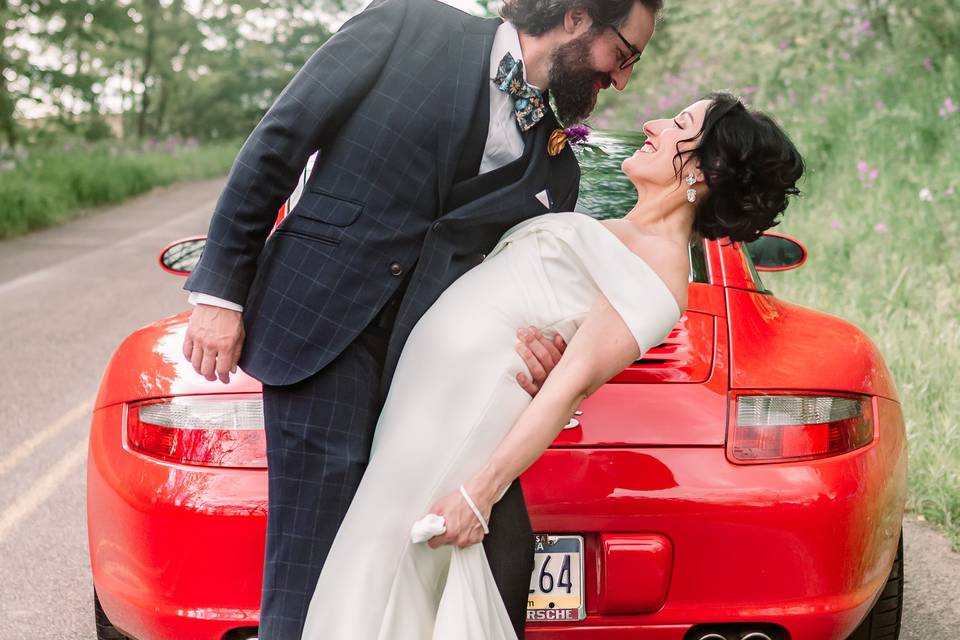 Groom dips bride at Porsche