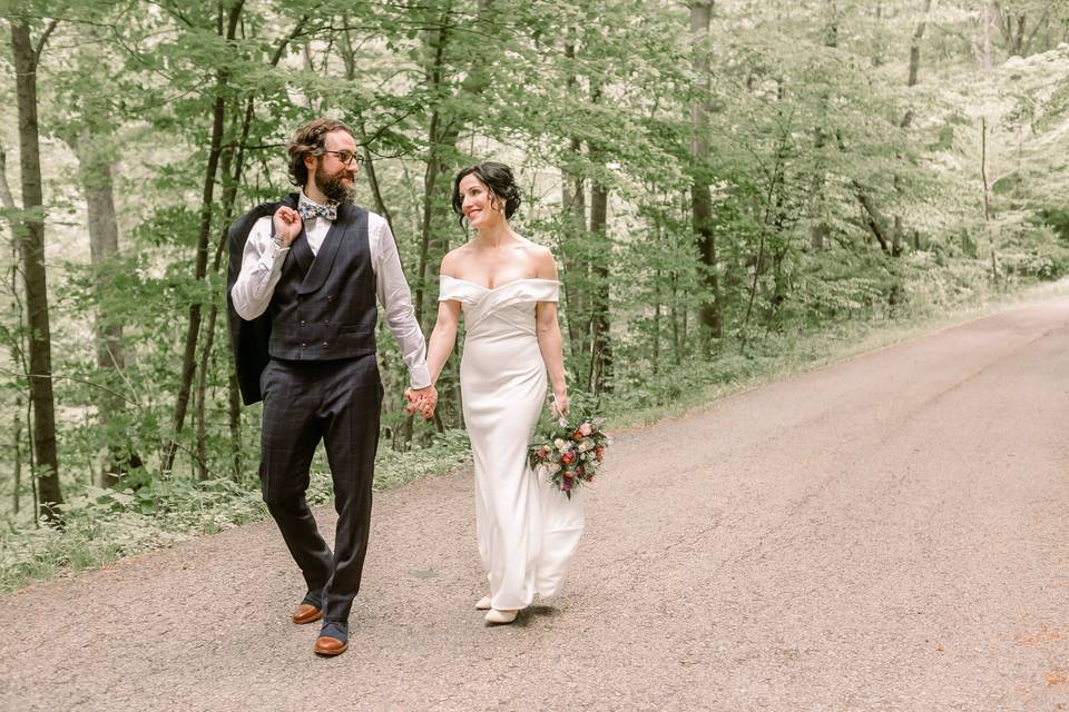 Bride and groom walk on path