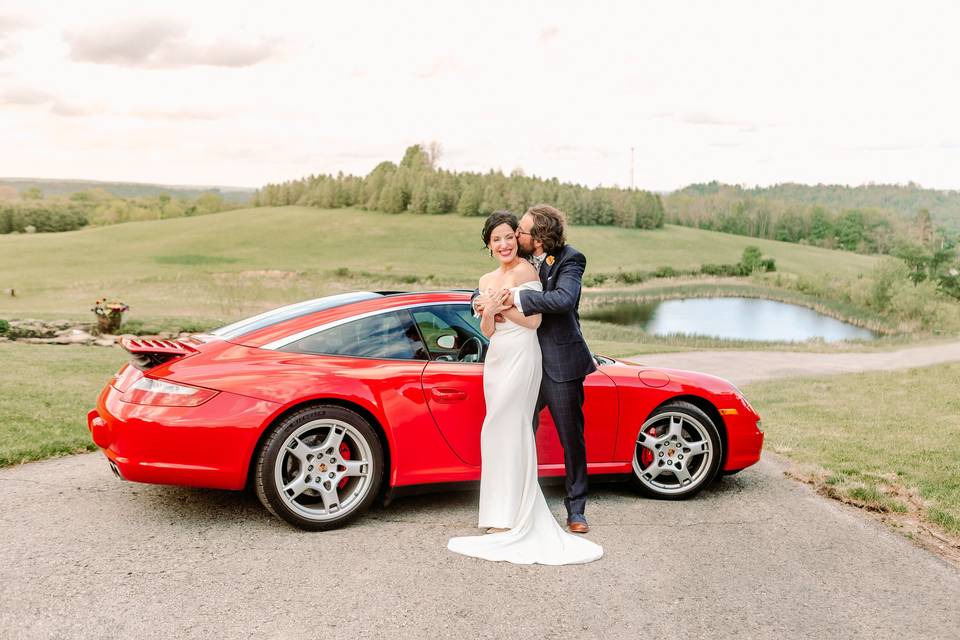 Groom kisses bride at Porsche