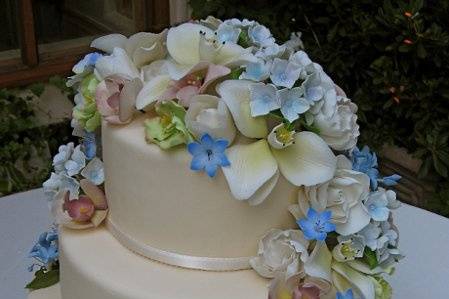 A simple 3 tiered fondant covered cake with a heavy cascade of mixed, sugar florals