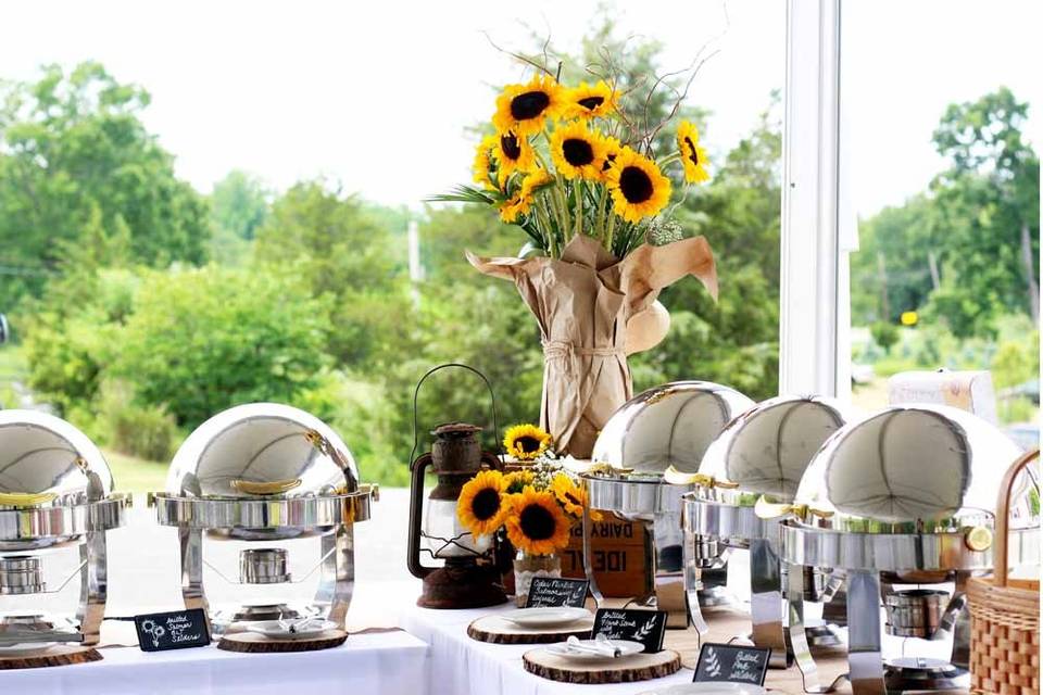 Buffet with vintage lanterns and sunflower floral arrangements to match the bride's decorations