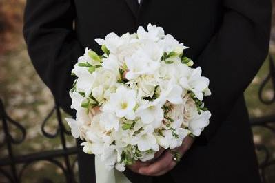 Groom holding his bride's bouquet