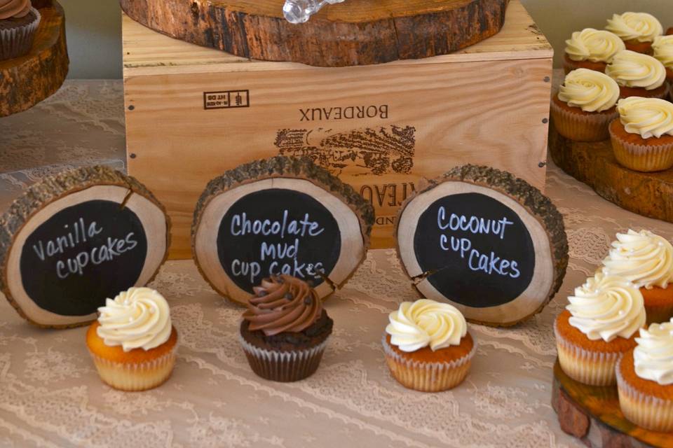 Rustic wedding setup with cake and cupcakes