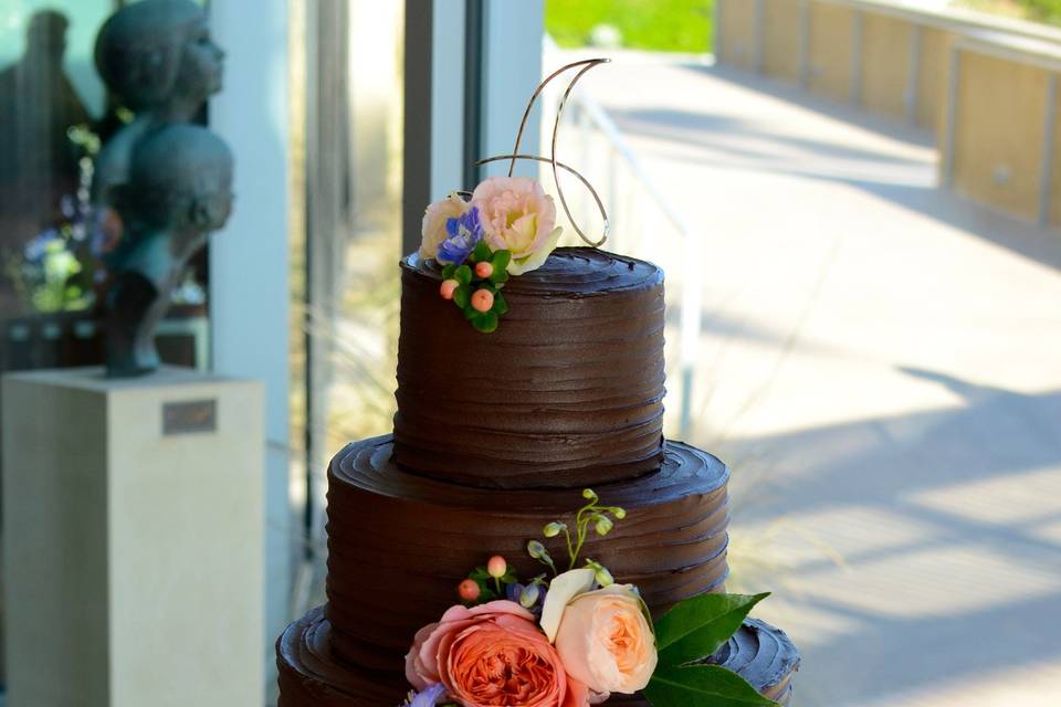 Delicious chocolate ganache covered cake with fresh flowers