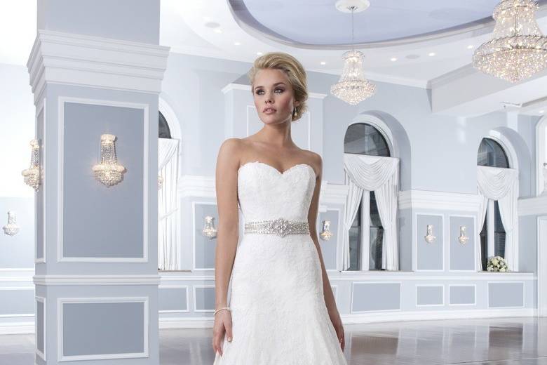 Style 6291
This effortlessly elegant satin A-line gown has a beautiful strapless neckline that is accented with a beaded belt. The back of the dress is adorned with satin and beaded buttons that cover the back zipper and trickle down the end of the chapel length train.