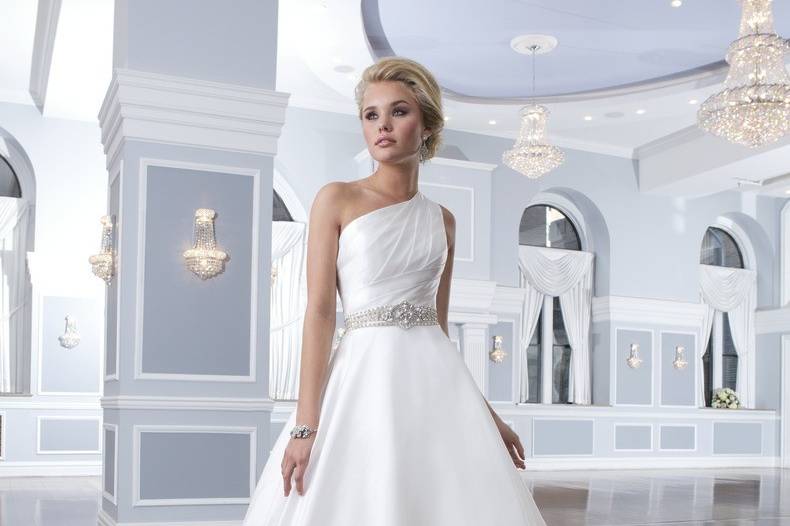 Style 6296
This strapless gown is asymmetrically draped in laser cut organza pleats to form an A-line silhouette. The layered organza ruffles in the skirt add more volume to the gown. The dress has a delicate semi-chapel length train and organza buttons that cover the back zipper.