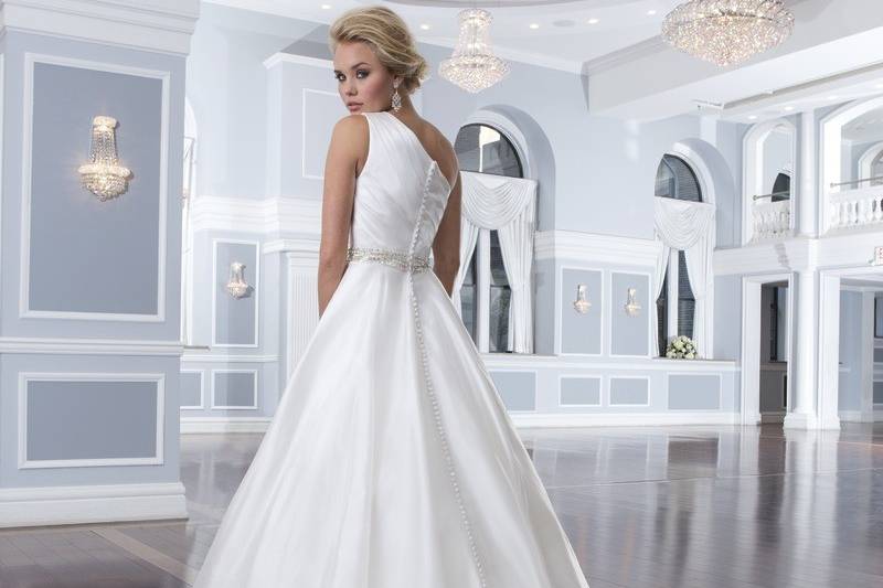 Style-Back 6296
This strapless gown is asymmetrically draped in laser cut organza pleats to form an A-line silhouette. The layered organza ruffles in the skirt add more volume to the gown. The dress has a delicate semi-chapel length train and organza buttons that cover the back zipper.