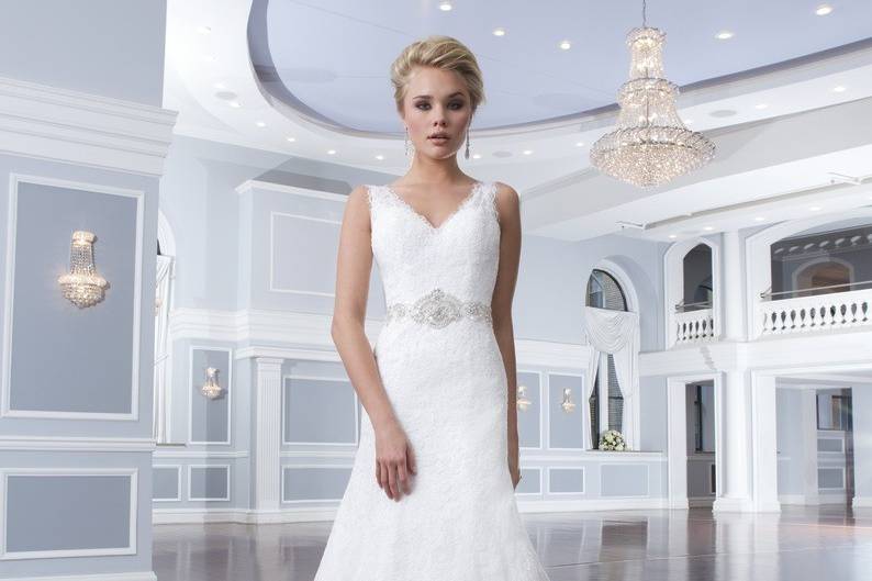 Style 6301
This sweetheart neckline is made of Alencon lace over tulle and features a basque waistline. The full organza ball gown has organza buttons over the back zipper and ends with a chapel length train. The dress also includes a detachable lace halter collar.