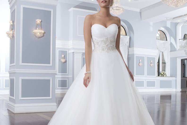 Style 6302
This lace tiered A-line gown has a V-neckline with a beaded belt at the natural waistline. The back of this dress has a deep sheer lace V-back neckline that is accented with lace buttons that trickle down to the end of the chapel length train.