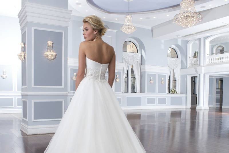 Style-Back 6302
This lace tiered A-line gown has a V-neckline with a beaded belt at the natural waistline. The back of this dress has a deep sheer lace V-back neckline that is accented with lace buttons that trickle down to the end of the chapel length train.