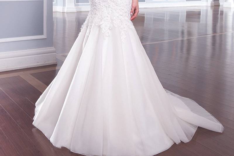 Style 6303 <br> This sweetheart tulle draped bodice has a heavy pearl beaded cummerbund that cinches the natural waist of this full tulle skirt. Tulle buttons cover the back zipper and ends with a chapel length train.