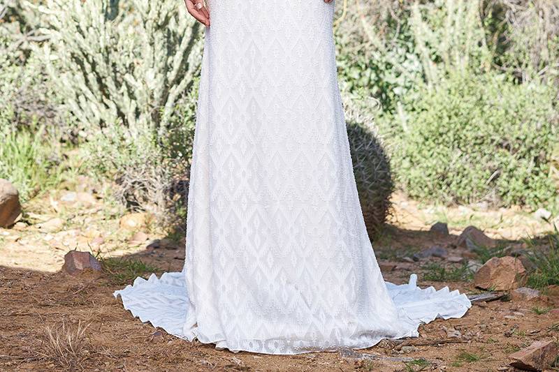 Lillian West	6522	<br>	Aztec chiffon feels organic in this illusion jewel neckline bloussant bodice. Shown with detachable subtle beaded self-tie belt. Accented by a low bloussant back bodice with buttons and loop closure.