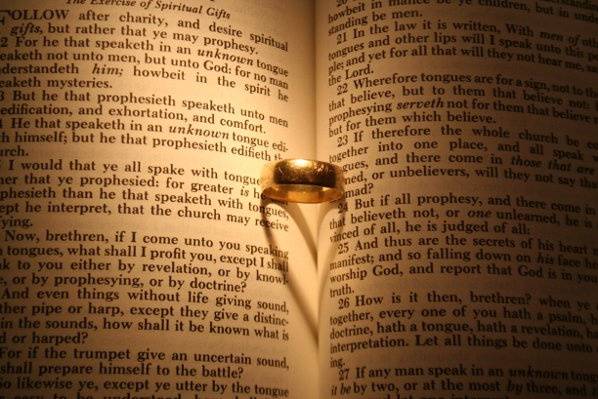 A ring on the Bible with special lighting creates a heart. Biblical Love.