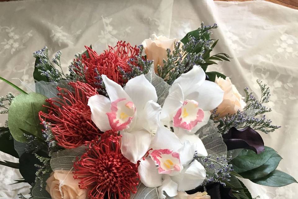 Cascade Bouquet made with preserved flowers. Cymbidium orchids, Pin Cushion Mums, Peach roses, and Eggplant Callas