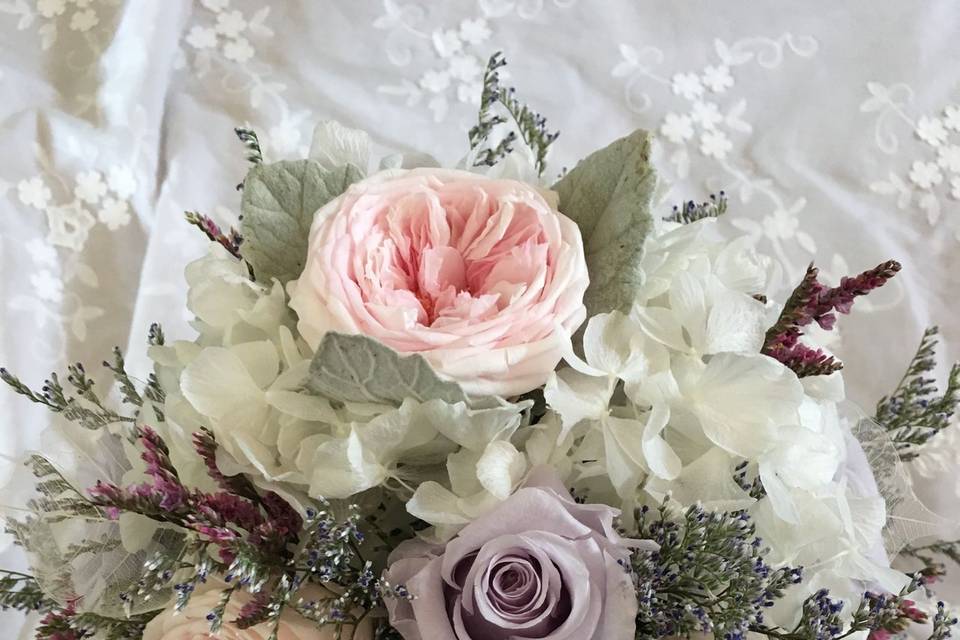 Hand tied bouquet using preserved Flowers. Pink Garden Roses, Lavender Roses, and White hydrangea. This is such a soft look!