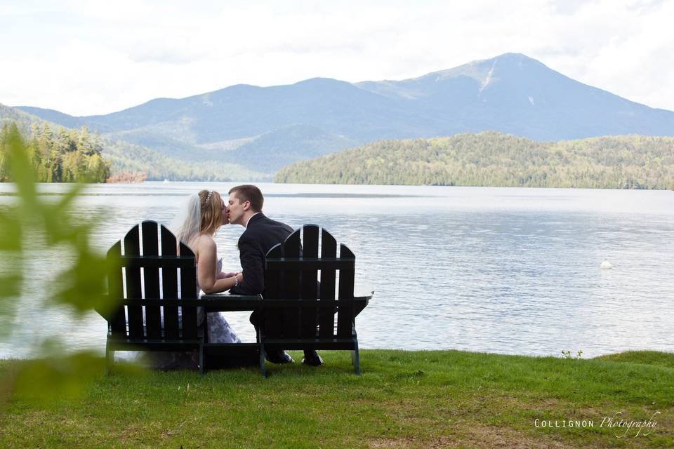Bride and Groom Kissing in Adirondack chairs, with a beautiful mountain backdrop