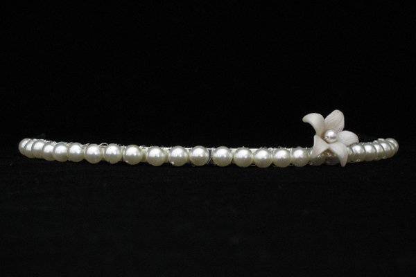 For a classy, simplistic style, Simplicity is perfect.  A single five-petal flower sits sweetly atop your head  amidst a strand of Swarovski Pearls hand-tied into the band. This tiara beautifully illustrates the 