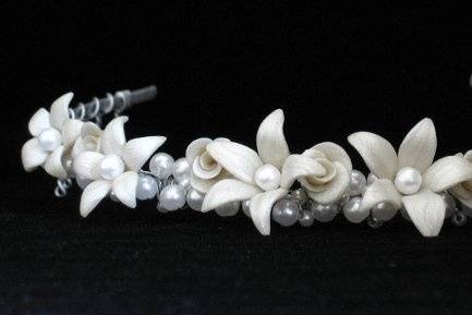 This beautiful tiara features an elegant arrangement of hand-sculpted clay lilies and roses nestled among clusters of Swarovski Pearls. The Lily Tiara is one of our most stunning designs. $145