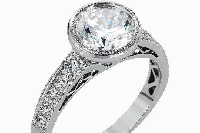 SIMON GNR501This modern white gold engagement ring features a lovely bezel setting and is accentuated by .31 ctw shimmering princess cut diamonds.