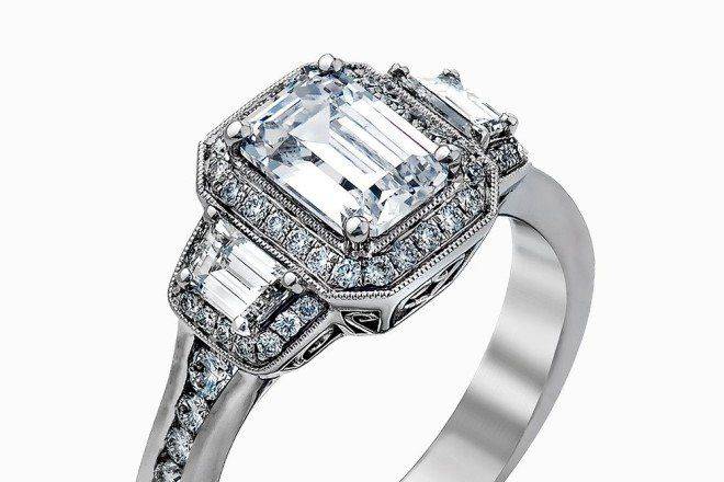 SIMON GMR2386Featuring a lovely romantic setting, this white gold contemporary ring features an exquisite halo and .33 ctw of shimmering round cut white diamonds complemented by .34 ctw of trapezoid side diamonds.