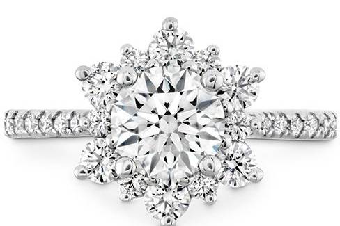 HEARTS ON FIREDELIGHT LADY DI A center diamond is surrounded by a wreath of smaller diamonds and a diamond-intensive band for a ring with a unique, snowflake-like shape.