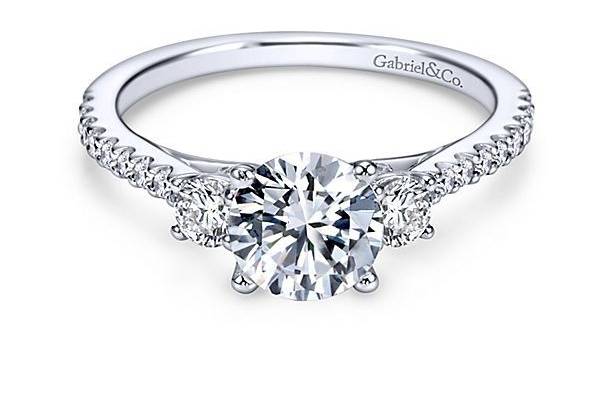 GABRIEL & COCHANTALThis three stone engagement ring is beautifully handcrafted with a trifecta of dazzling diamonds beneath the center stone and graduating diamonds down each side.