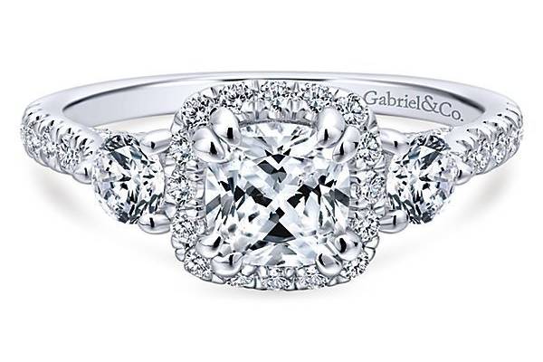 GABRIEL & COHOPEIn this swoon-worthy halo engagement ring, a pair of round cut diamond side stones accentuate a cushion cut center stone. Dazzling accent diamonds dance along the shank and onto the gallery and bridge.