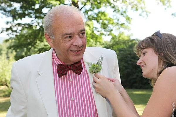 Eutopia Events pinning a boutonniere on the father-of-the-groom