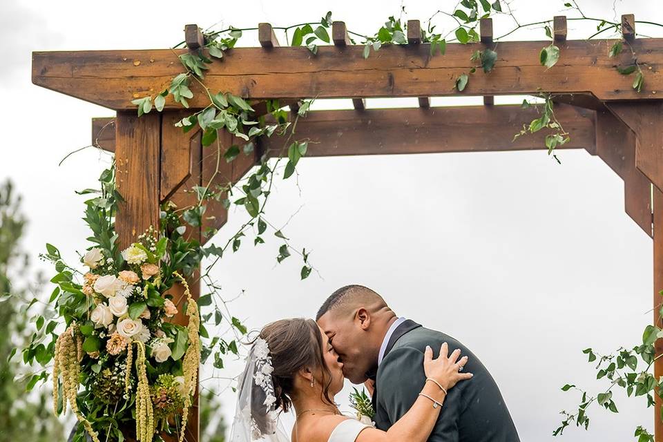Couple under wedding arbor