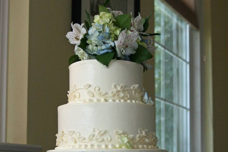 Rose- Buttercream cake with a ribbon on vines and leaves