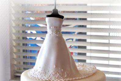 This cake was for a Wedding Shower.  The dress on top is made out of sugar paste and is a replica of her dress.   The design around the cake was the design for her invitations and napkins.
