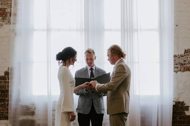 Couple exchanging vows by windows