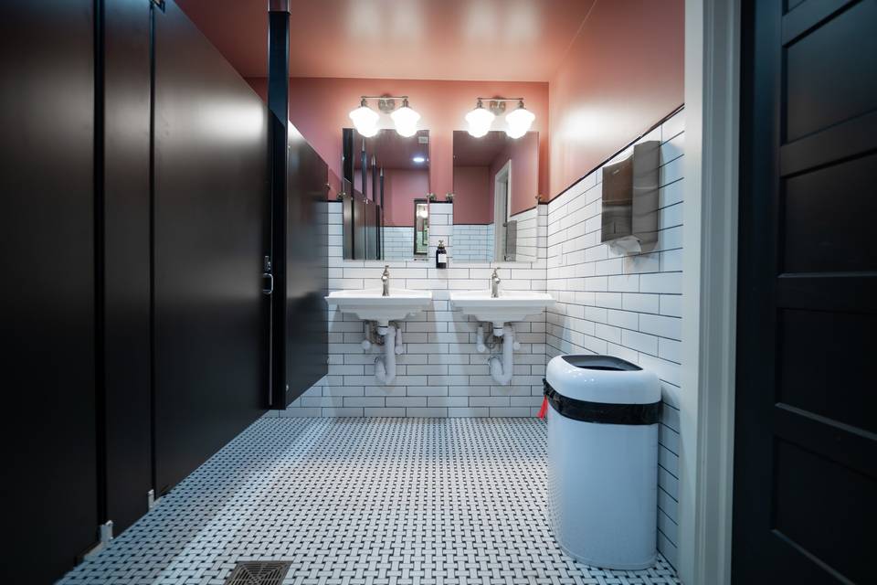 Pink restroom with dual sinks