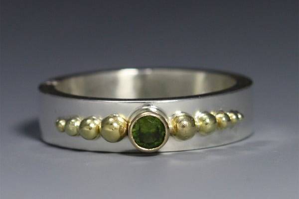 10 Ball Crown Ring with Stone (Peridot)
Sterling silver and 14 karat gold ring with peridot stone. Can be made to order with any stone. For more info, use the link provided.
http://www.etsy.com/listing/71231462/10-ball-crown-ring-w-stone-14k-peridot