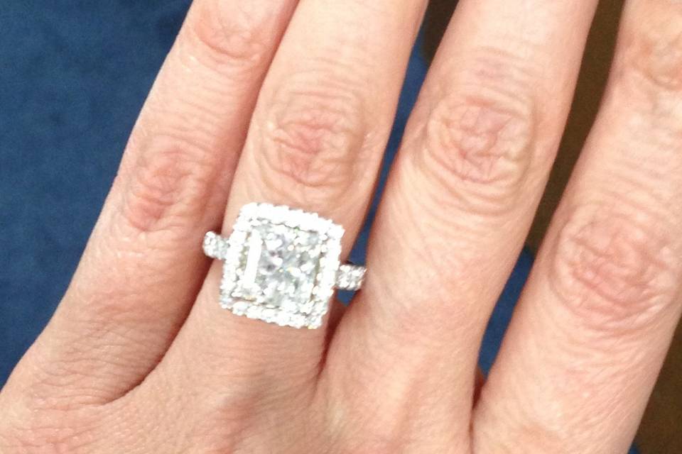 A stunning square cut center framed by a diamond studded halo.
18K White Gold