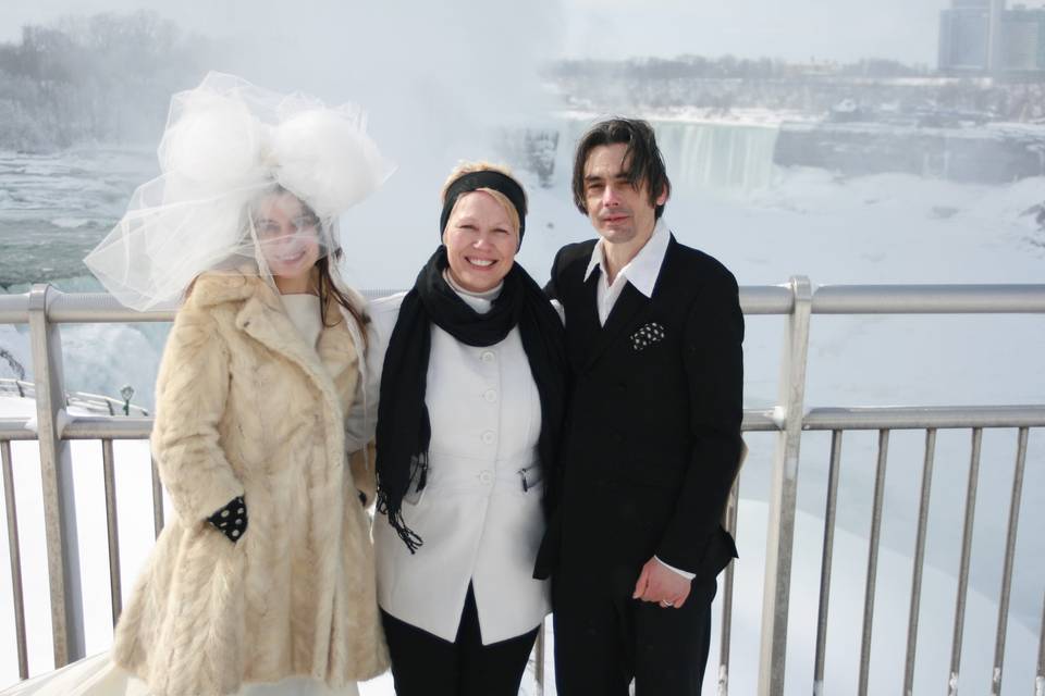 Officiant and newlyweds in the snow