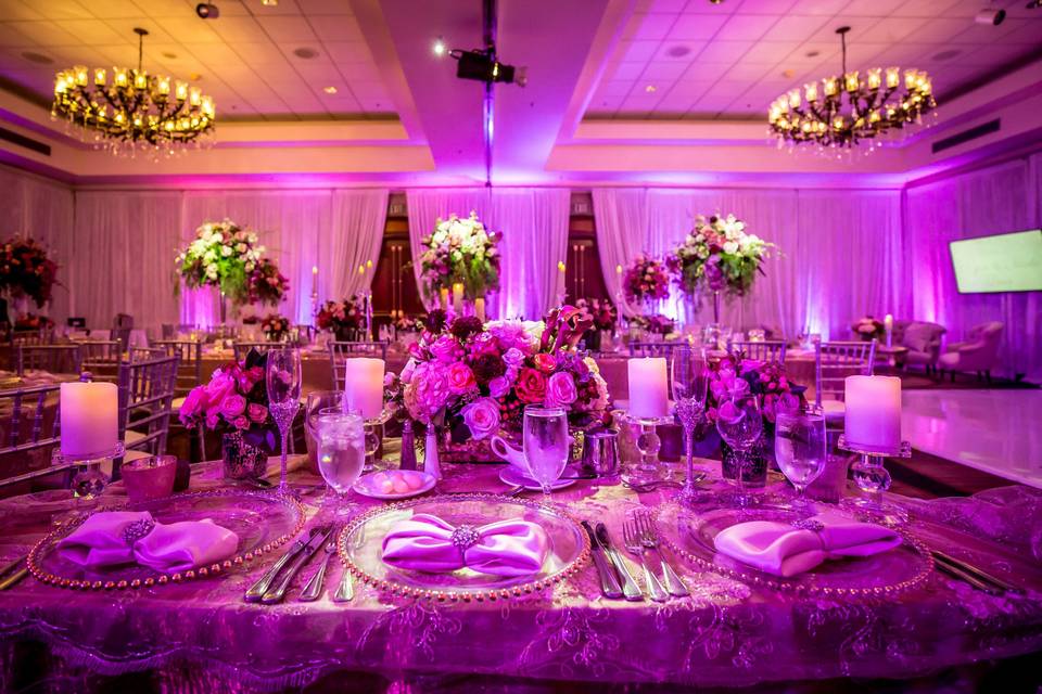 Floor to ceiling white drapery with purple uplighting