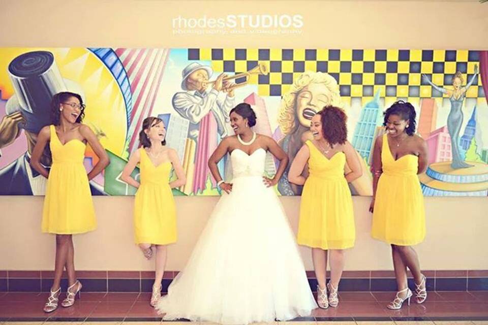 Bride and her bridesmaids by the wall art
