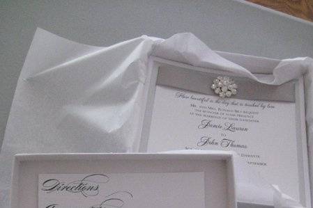 Boxed invitation in metallic white box, interior pocket inside lid, jewel accented silver and metallic white invitation.