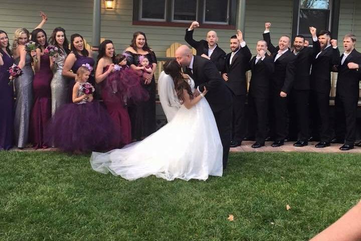 Behind the scenes photo of bride and groom, entire wedding party