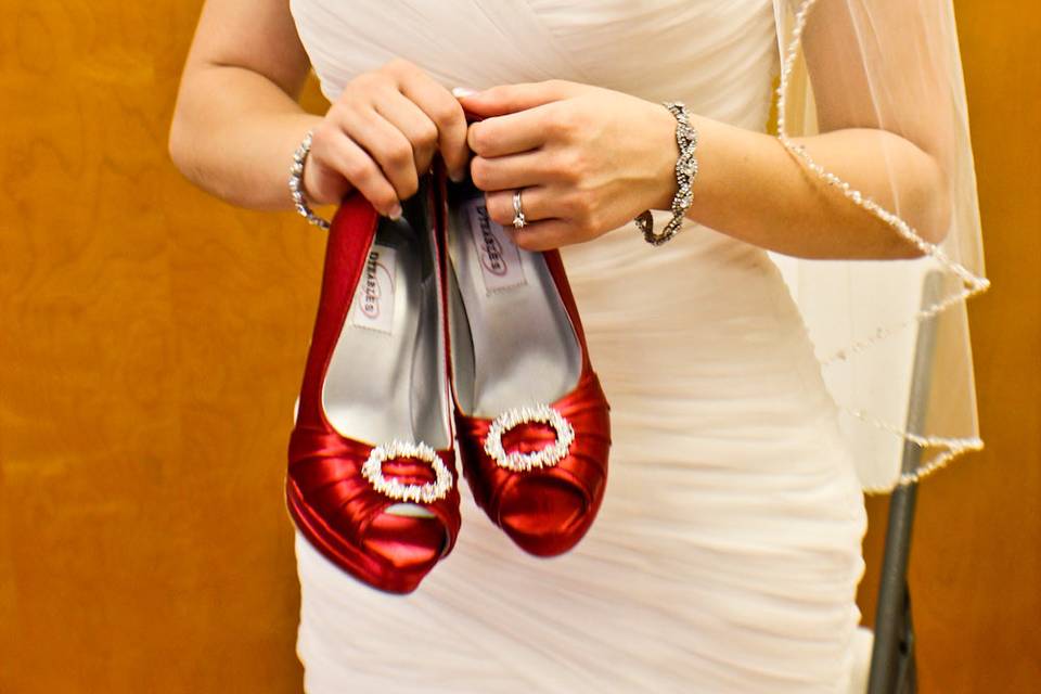 The bride holding her shoes