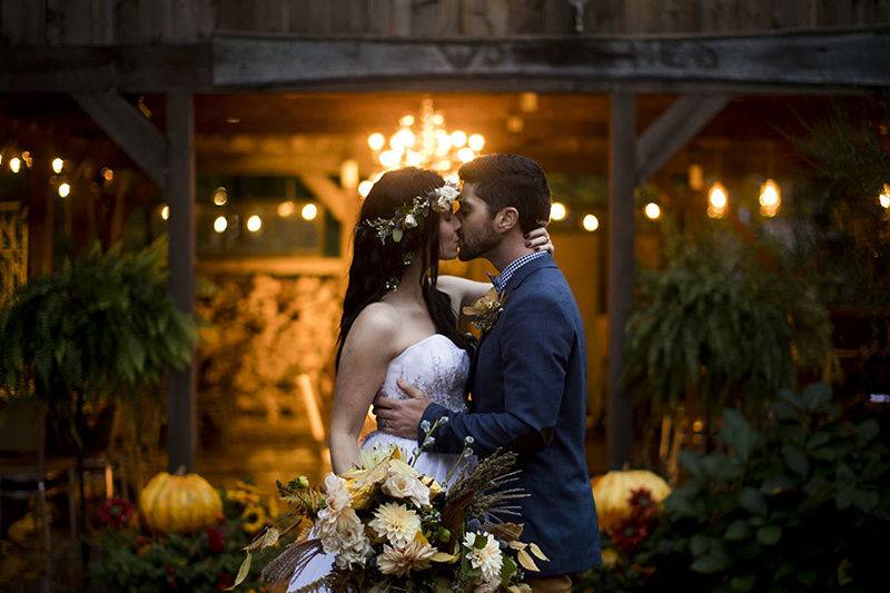 Newlyweds kissing outside the barn