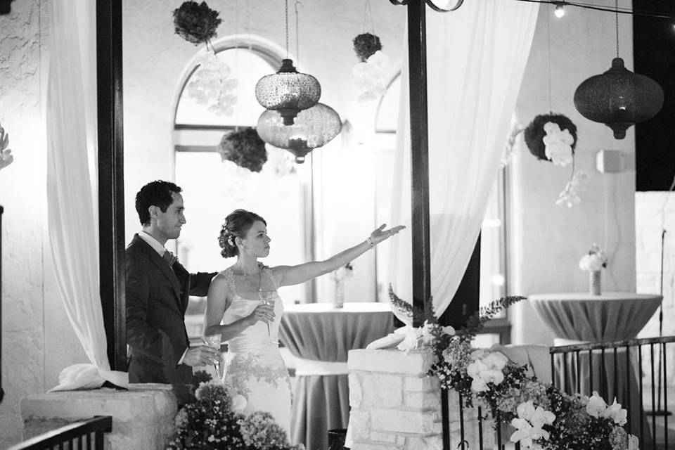 Newly married, greeting guests amid Moroccan hanging garden and floral handrail. Photo by Jake Holt Photography.