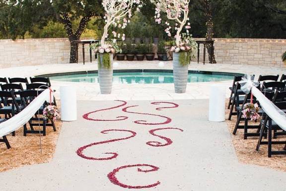 Rose-swirl pattern aisle runner leading to hanging orchid altarpieces. Photo by Jake Holt Photography.