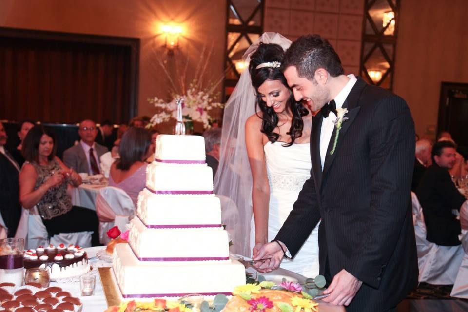 Candid moment of Vasiliki & George as they cut their first slide of cake together